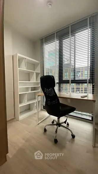 Modern study room with sleek desk and ergonomic chair, featuring large window and natural light.