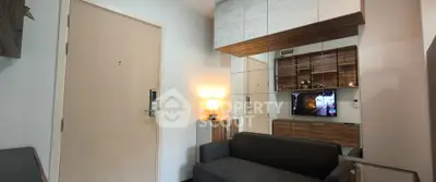 Modern living room with sleek design and cozy ambiance, featuring a stylish sofa and wall-mounted TV.