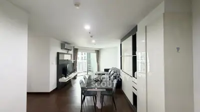 Modern living room with dining area and sleek furniture in a bright apartment.