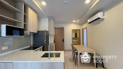 Modern kitchen with dining area featuring sleek cabinetry and built-in appliances.