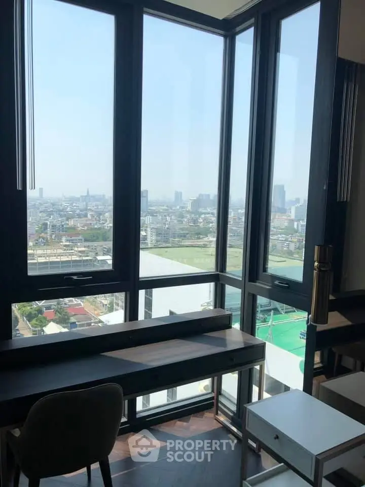 Stunning high-rise apartment with panoramic city views from floor-to-ceiling windows.