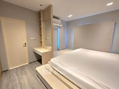 Modern minimalist bedroom with platform bed and built-in storage in a stylish apartment.