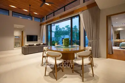 Luxurious open-plan living room with elegant dining area and garden view, featuring modern decor and high ceilings.