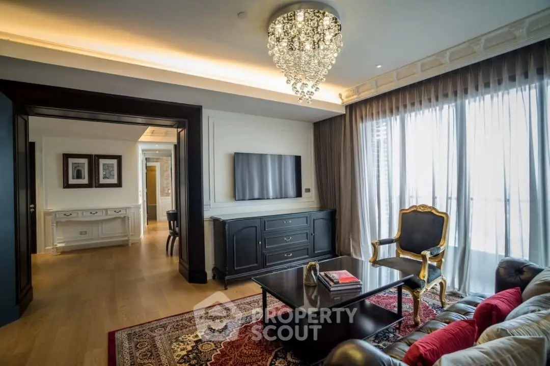 Luxurious living room with elegant chandelier and large windows in a high-end apartment.
