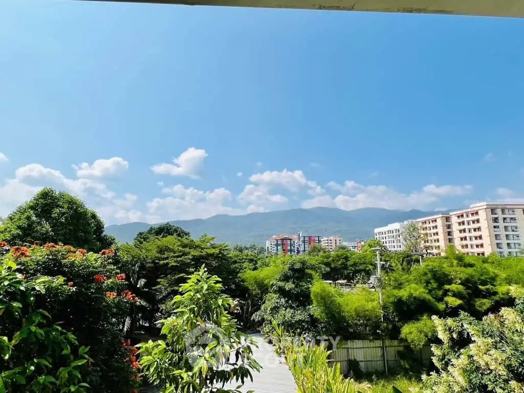 Scenic view from a balcony overlooking lush greenery and distant mountains, perfect for nature lovers.