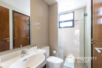 Modern bathroom with glass shower and sleek fixtures in contemporary home