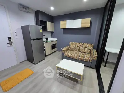 Modern living room with stylish furniture and compact kitchen in open layout apartment.
