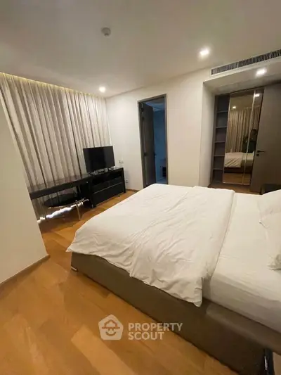 Modern bedroom with sleek furniture and ambient lighting, featuring a comfortable bed and stylish decor.