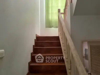 Charming wooden staircase with natural light and green curtains