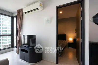 Modern living room with TV and air conditioning, adjacent to a cozy bedroom.