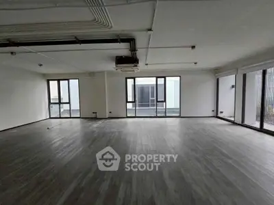 Spacious open-plan living area with large windows and modern flooring, ideal for customization.