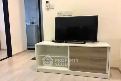 Modern living room with sleek TV stand and flat-screen TV, showcasing minimalist interior design.