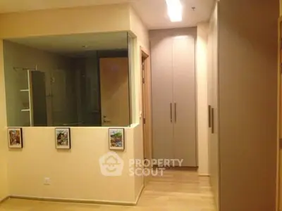 Modern hallway with built-in storage and glass partition in a stylish apartment.