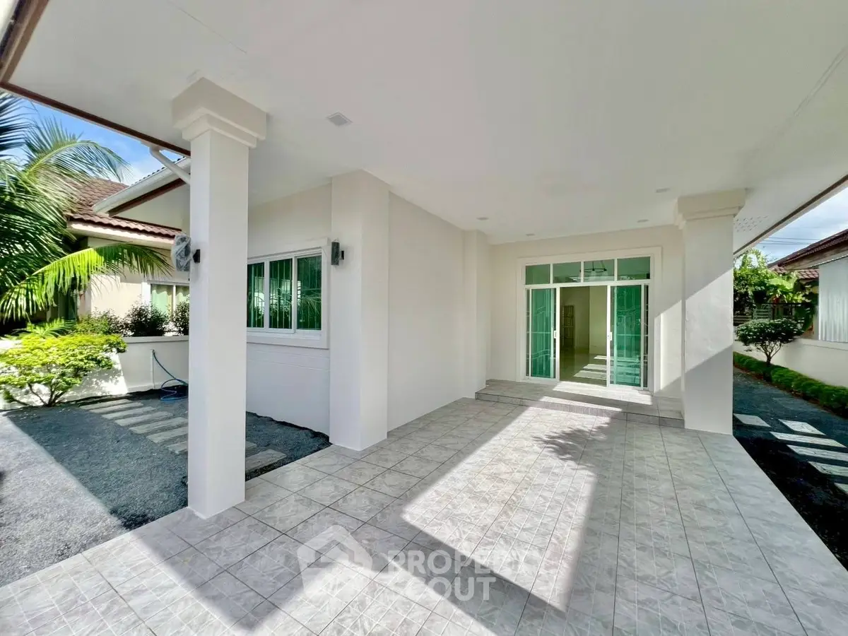 Spacious modern entrance with tiled flooring and lush greenery
