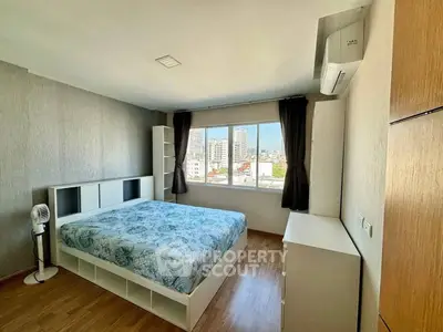 Spacious bedroom with city view, modern furnishings, and ample natural light.