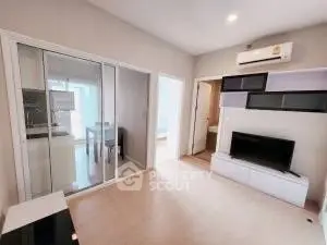 Modern living room with sleek design and sliding glass doors leading to a dining area.
