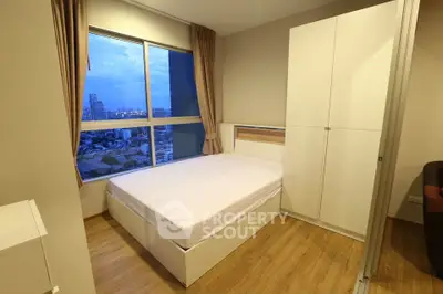 Modern bedroom with city view, featuring a large window and sleek white furniture.