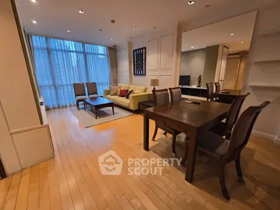 Spacious open-plan living and dining area with elegant wooden flooring and modern furnishings.