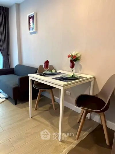 Cozy modern living room with dining area, featuring elegant table setting and stylish decor.
