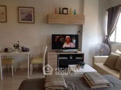 Cozy living room with modern decor, TV setup, and dining area in a bright apartment.