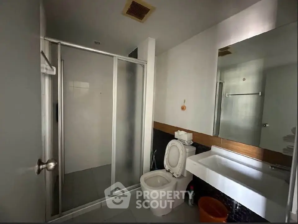 Modern bathroom with glass shower and sleek fixtures in a contemporary home.