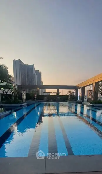 Luxurious rooftop pool with stunning cityscape views at sunset, perfect for relaxation and leisure.