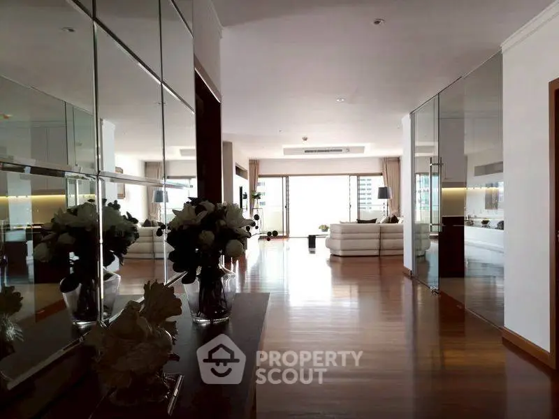 Spacious modern living room with mirrored walls and elegant decor