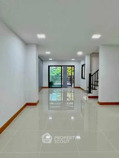 Spacious modern living room with glossy tiled floors and large windows