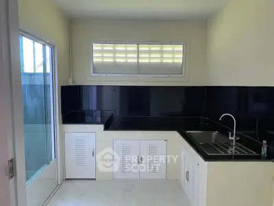 Modern kitchen with sleek black countertops and white cabinetry