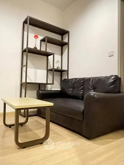 Modern living room with sleek black sofa and stylish shelving unit