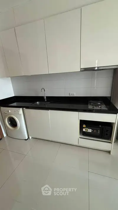Modern kitchen with sleek cabinets, washing machine, and built-in appliances
