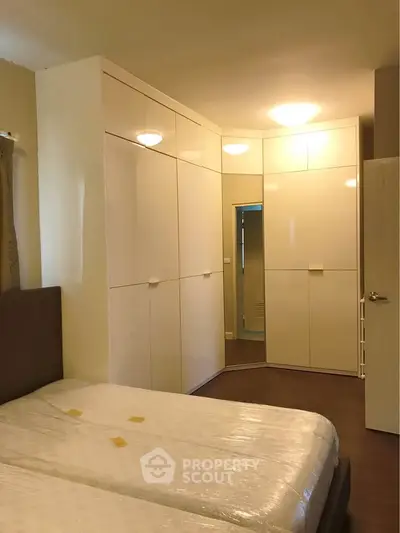 Spacious bedroom with modern built-in wardrobes and cozy lighting