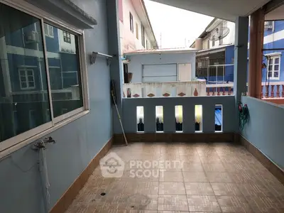 Spacious balcony with tiled floor and blue walls in residential area