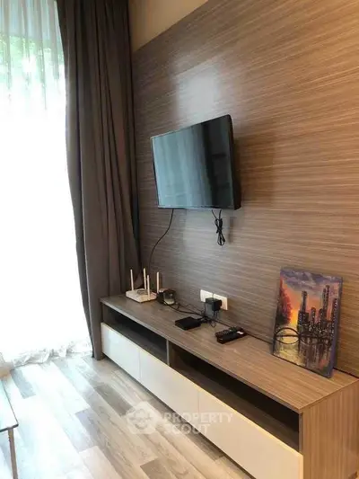 Modern living room with mounted TV and stylish wooden entertainment unit.