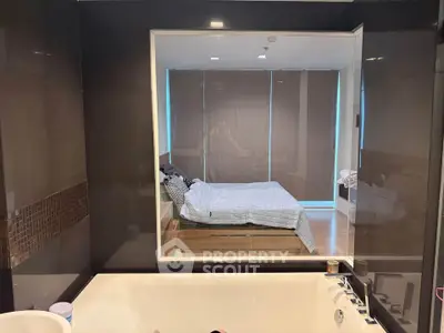 Modern bathroom with a view into a stylish bedroom, featuring a luxurious bathtub and sleek design.