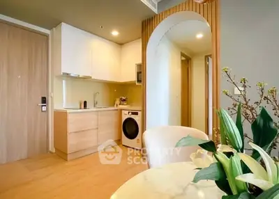 Modern kitchen with open layout and integrated washing machine in stylish apartment.