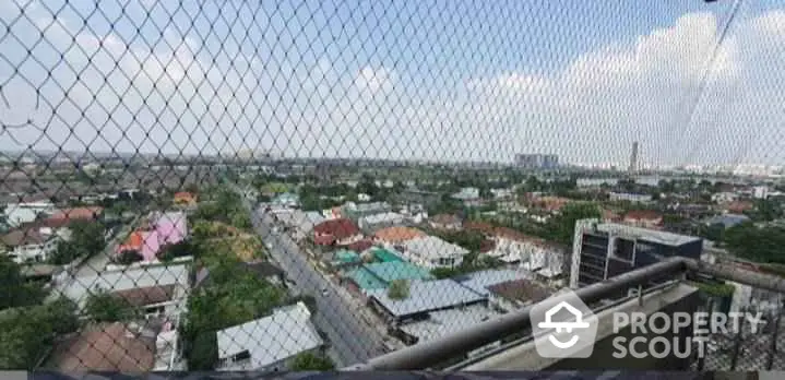 Stunning panoramic city view from high-rise balcony with safety netting.