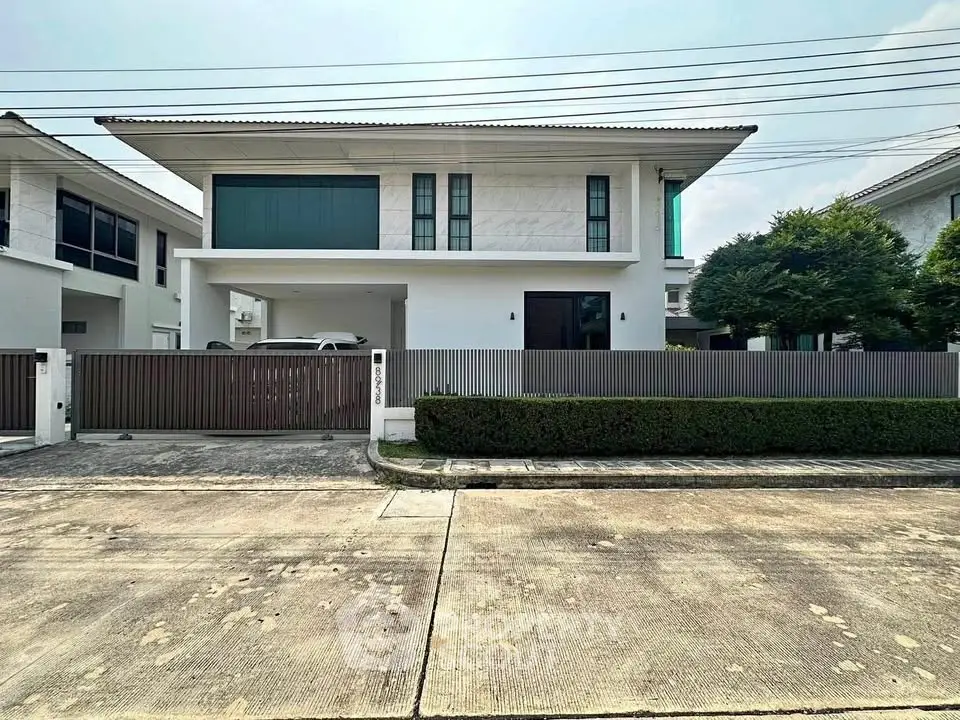Modern two-story house with sleek design and spacious driveway in a suburban neighborhood.