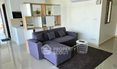 Modern living room with stylish sofa and open kitchen layout in a contemporary apartment.
