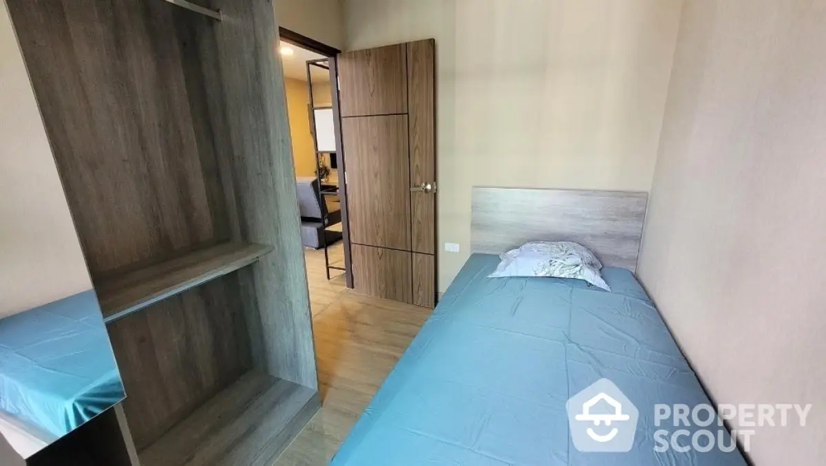 Cozy bedroom with single bed and wooden wardrobe, ideal for minimalist living.