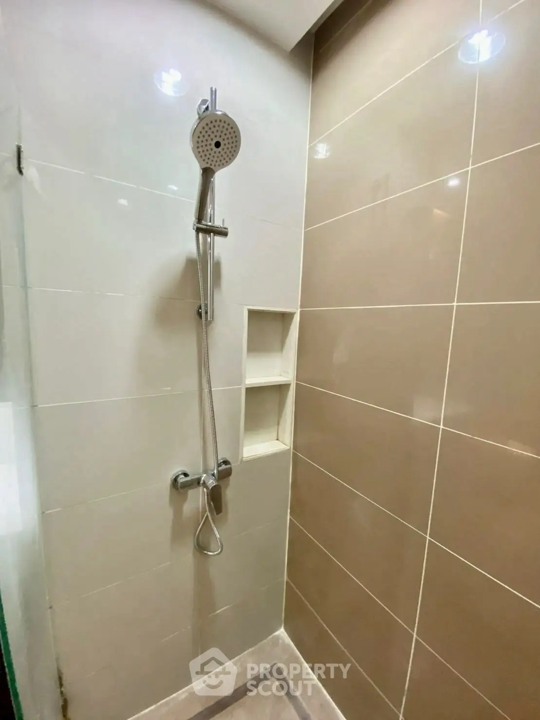 Modern bathroom shower with sleek tile design and built-in shelving
