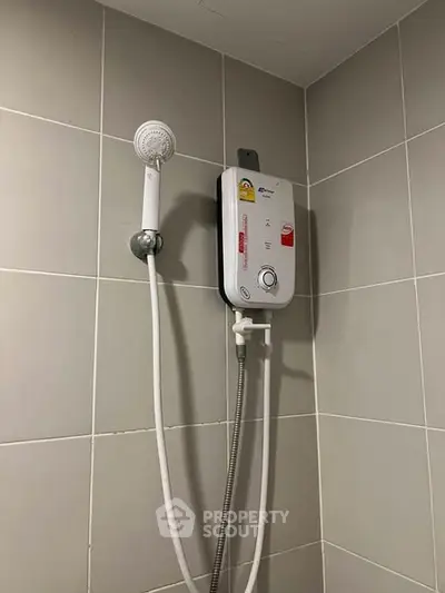 Modern bathroom with sleek shower unit and tiled walls.