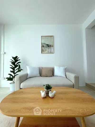 Modern living room with stylish sofa and wooden coffee table in a bright, minimalist design.