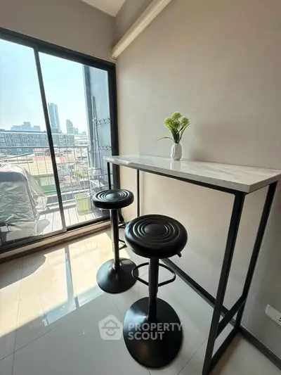 Modern balcony with sleek bar stools and city view, perfect for urban living.