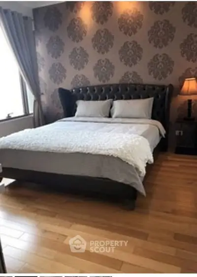 Luxurious bedroom with elegant wallpaper and plush bed in a stylish apartment.