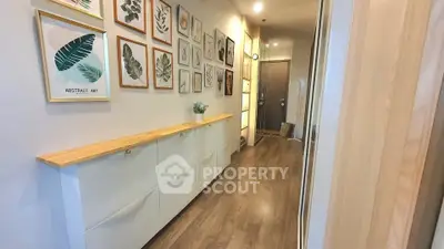 Stylish hallway with wooden flooring and modern art decor in a contemporary apartment.