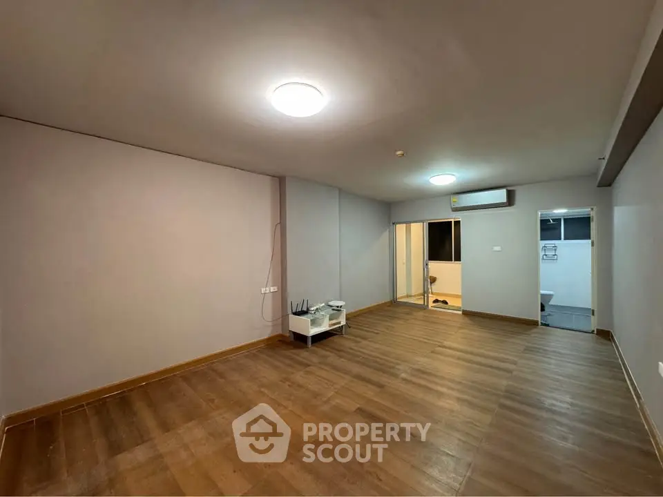 Spacious empty living room with wooden flooring and modern lighting