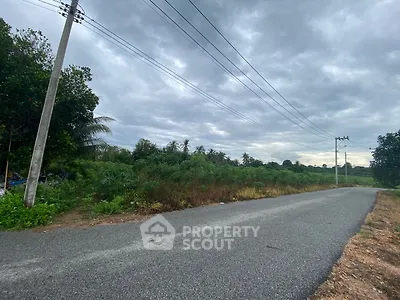 Scenic rural road with lush greenery and cloudy sky, ideal for tranquil living.