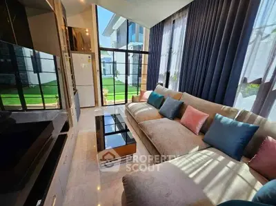 Luxurious living room with plush sectional sofa and floor-to-ceiling windows overlooking a lush garden.