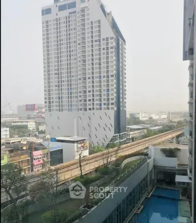 Stunning cityscape view from high-rise building with pool and modern architecture.